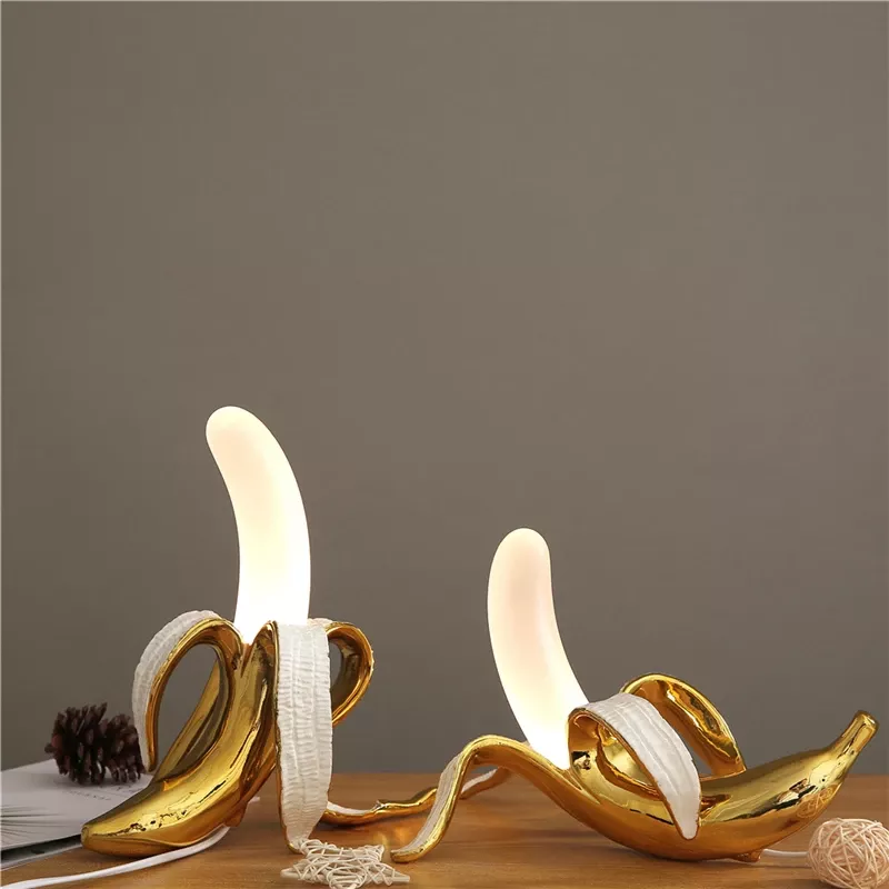 Golden banana night lights on wooden table.