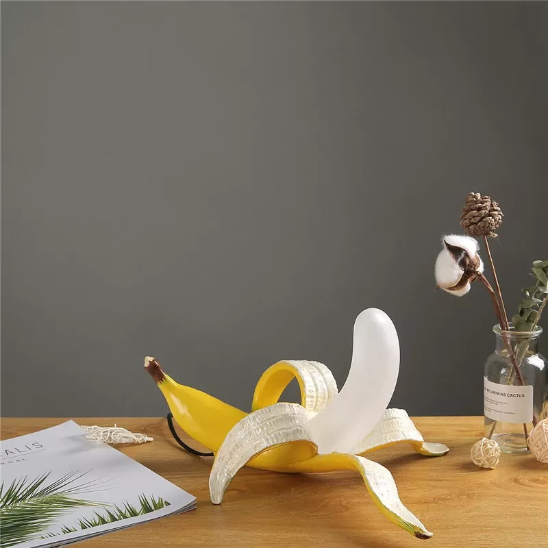 Decorative peeled banana vase on wooden table.