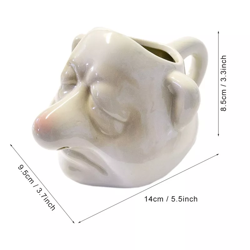 Ceramic mug with face design, measurements shown.