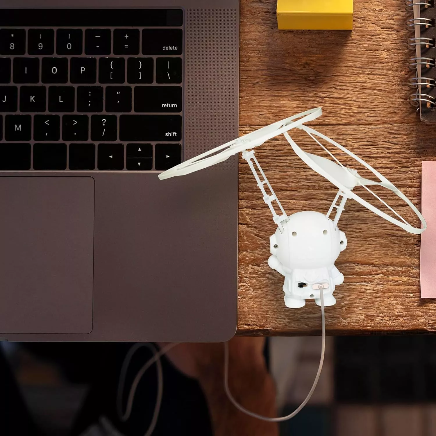 Laptop with cute drone gadget on wooden desk