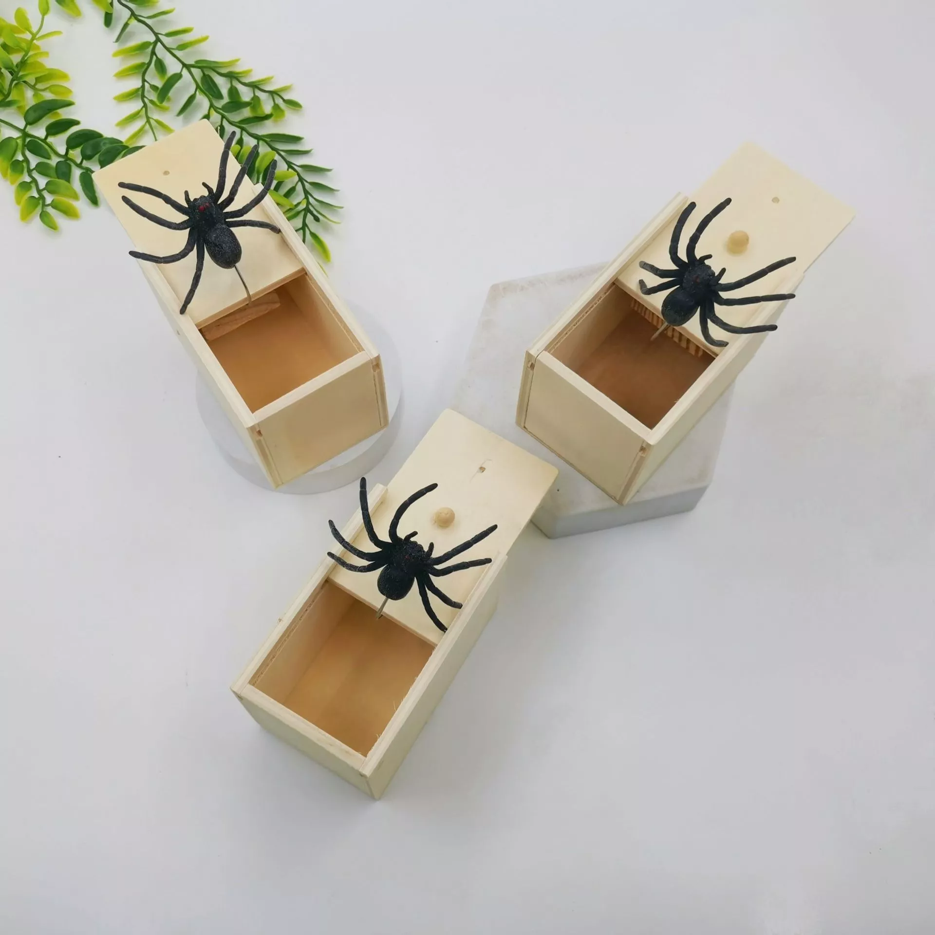 Three toy spider prank boxes on display.