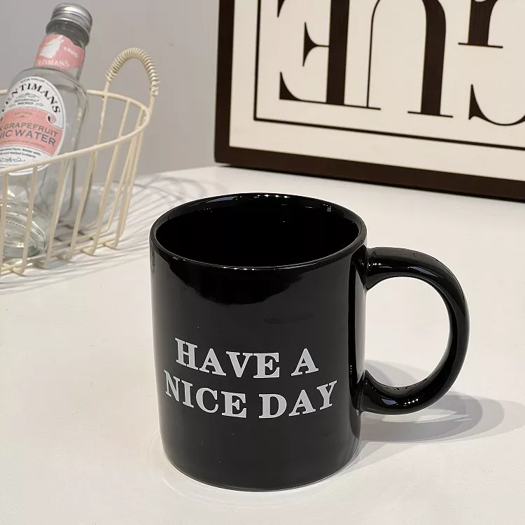 Black mug with 'Have a Nice Day' text.