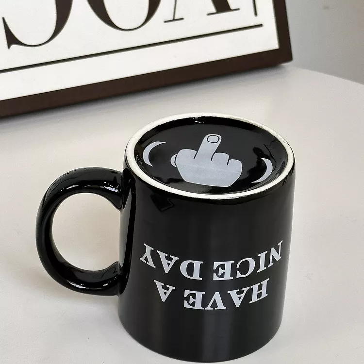 Black mug with offensive gesture design.