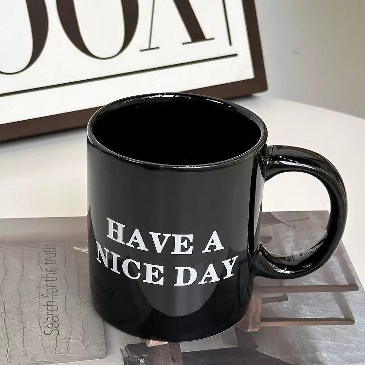 Black mug with 'Have a Nice Day' text.