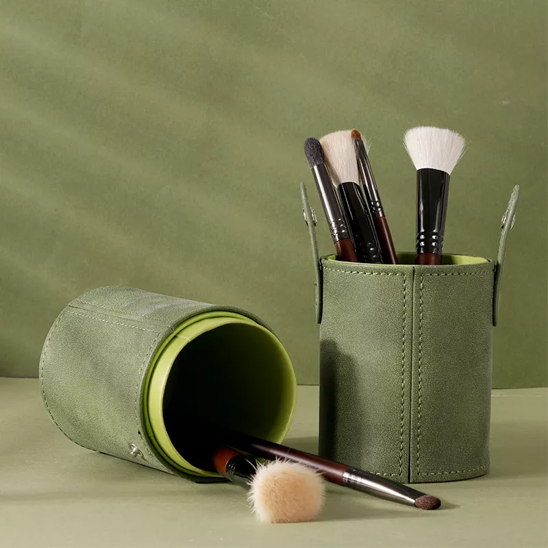Green makeup brush holder with brushes