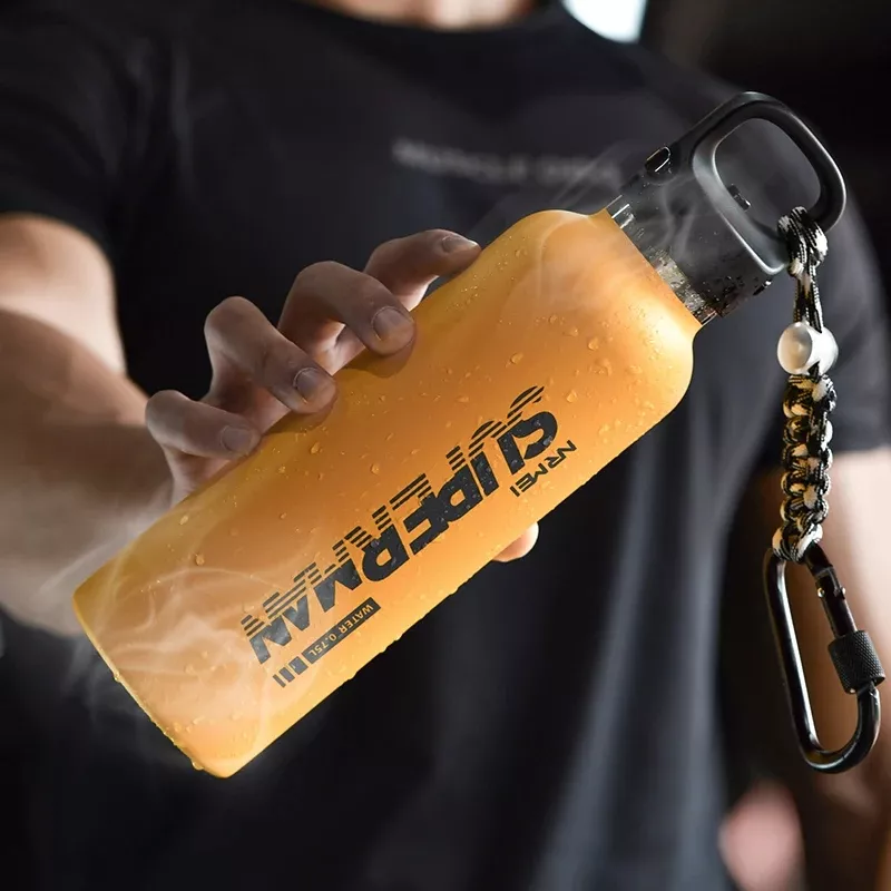Person holding orange insulated water bottle