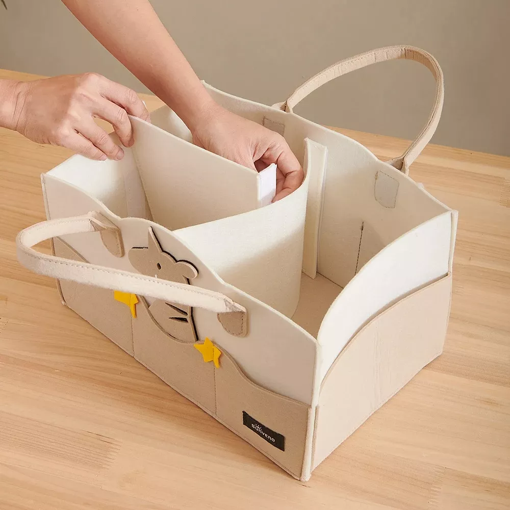 Person organizing items in beige storage basket.