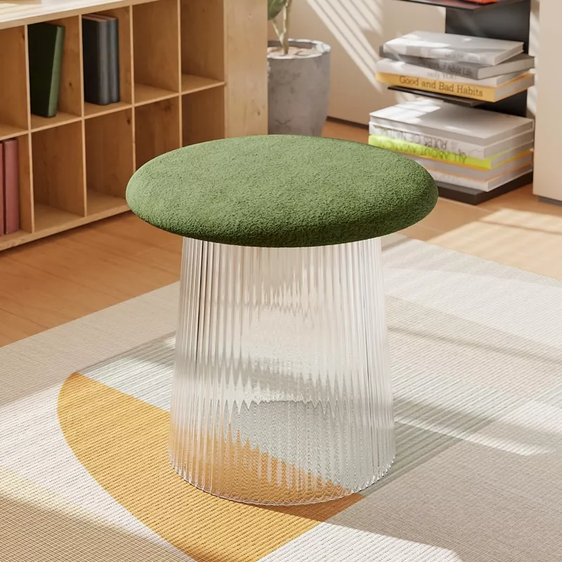Green cushioned stool with transparent base in room.